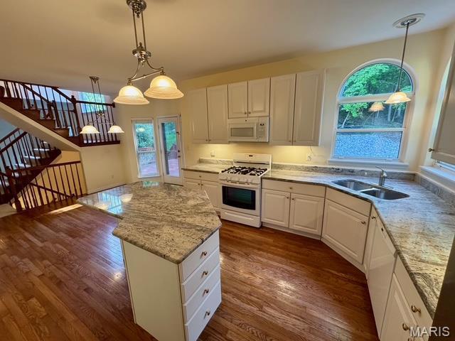 650 Legends View Dr, Eureka, MO 63025 - kitchen with white appliances, a sink, dark wood finished floors, a kitchen island, and white cabinets