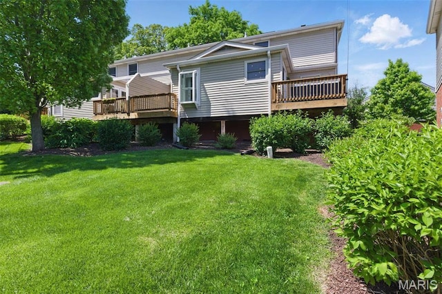 rear view of house featuring a deck and a yard