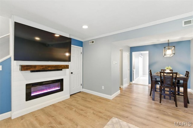 living area featuring baseboards, crown molding, a large fireplace, wood finished floors, and recessed lighting