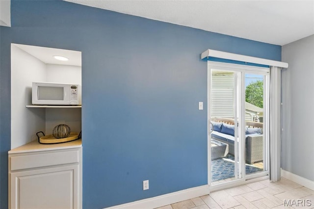 doorway to outside featuring baseboards