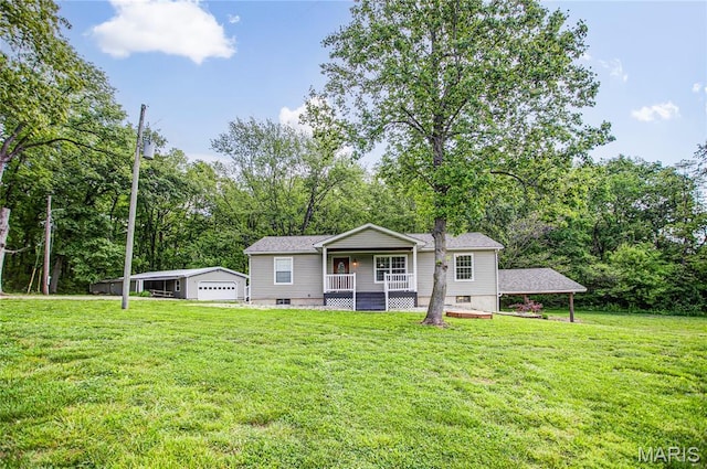 view of front of property with a porch, a front lawn, a detached garage, and view of scattered trees
