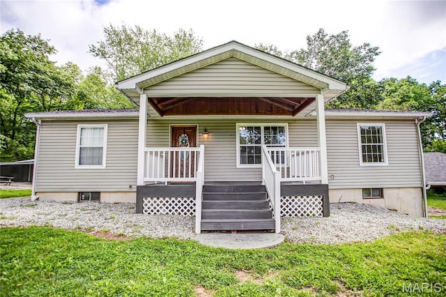 view of front of house featuring covered porch and a front lawn