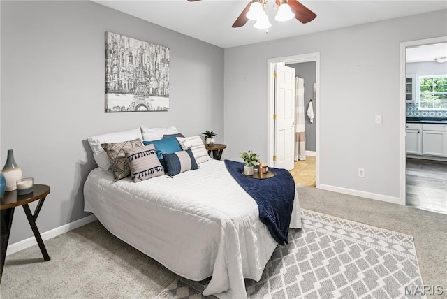 bedroom featuring carpet, ensuite bath, baseboards, and ceiling fan