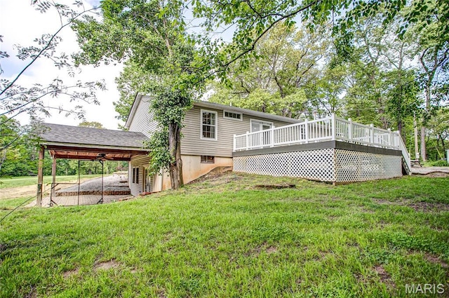 rear view of house with a lawn, a wooden deck, and a carport