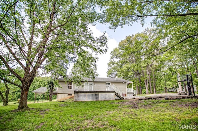 back of house with stairs, a yard, and a deck