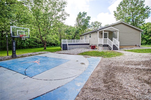 view of basketball court featuring basketball court and a lawn