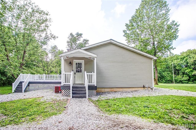 view of front of home featuring a wooden deck and a front lawn