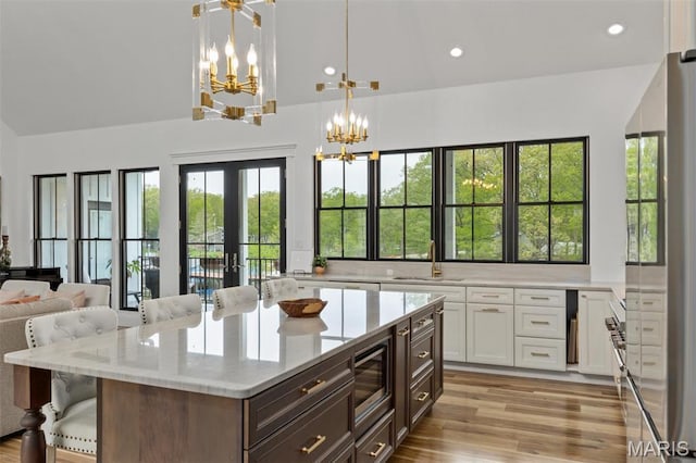 10028 Pineridge Dr, Effingham, IL 62401 - kitchen featuring appliances with stainless steel finishes, a sink, a chandelier, vaulted ceiling, and white cabinetry