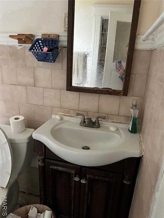 3636 Arkansas Ave, Saint Louis, MO 63118 - half bath featuring tile walls, decorative backsplash, vanity, and toilet