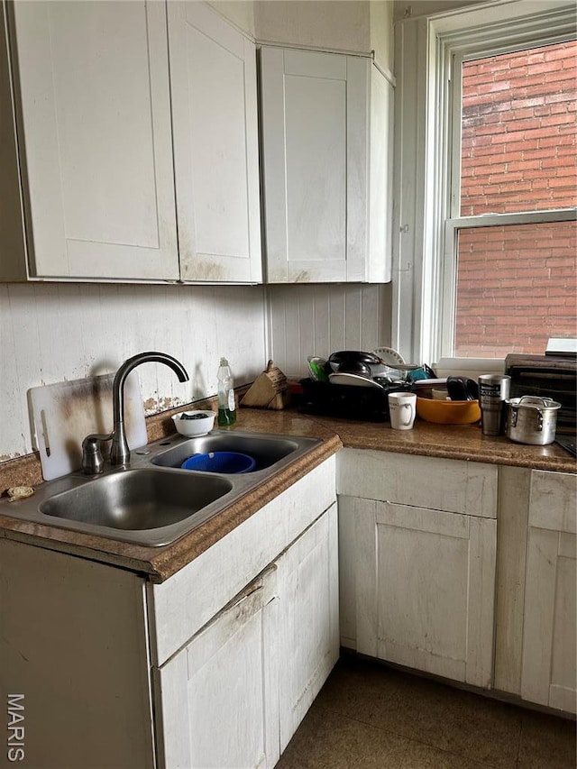 3636 Arkansas Ave, Saint Louis, MO 63118 - kitchen featuring a sink, dark countertops, and white cabinetry