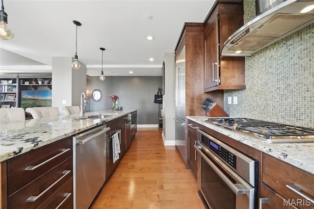 232 N Kingshighway Blvd Unit 907, Saint Louis, MO 63108 - kitchen featuring appliances with stainless steel finishes, wall chimney exhaust hood, decorative light fixtures, decorative backsplash, and light stone countertops