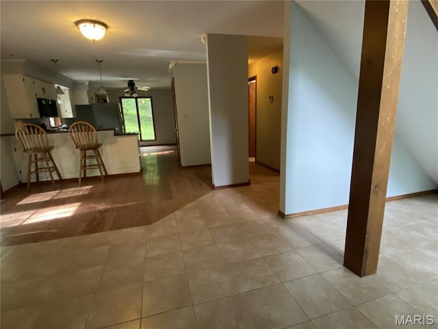236 Mohawk Dr, Cape Girardeau, MO 63701 - kitchen with a peninsula, a breakfast bar, dark countertops, tile patterned flooring, and white cabinets