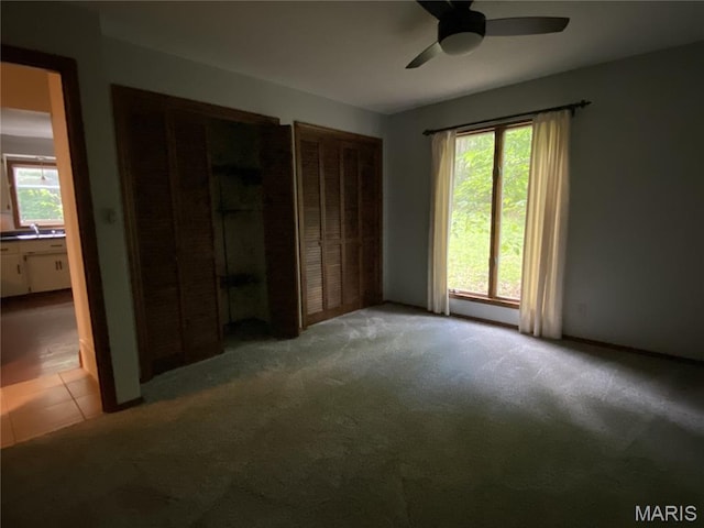 236 Mohawk Dr, Cape Girardeau, MO 63701 - unfurnished bedroom featuring carpet, a sink, a ceiling fan, and two closets