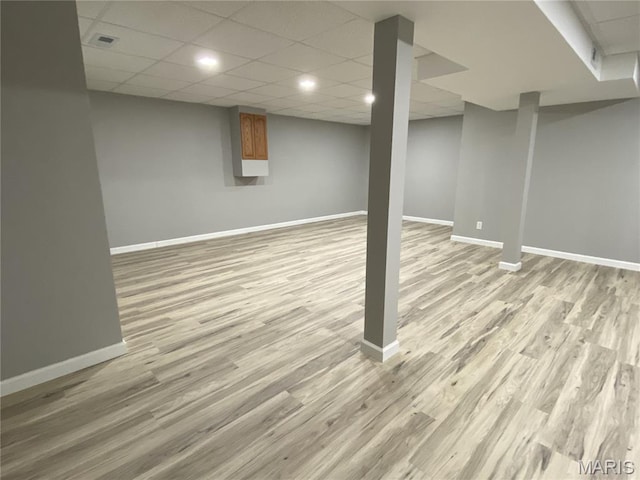 236 Mohawk Dr, Cape Girardeau, MO 63701 - finished below grade area featuring baseboards, light wood-style flooring, and a paneled ceiling