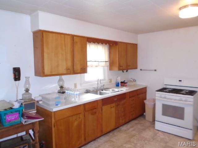 12 Tabitha Ln, Annapolis, MO 63620 - kitchen with gas range gas stove, a sink, light countertops, and brown cabinetry