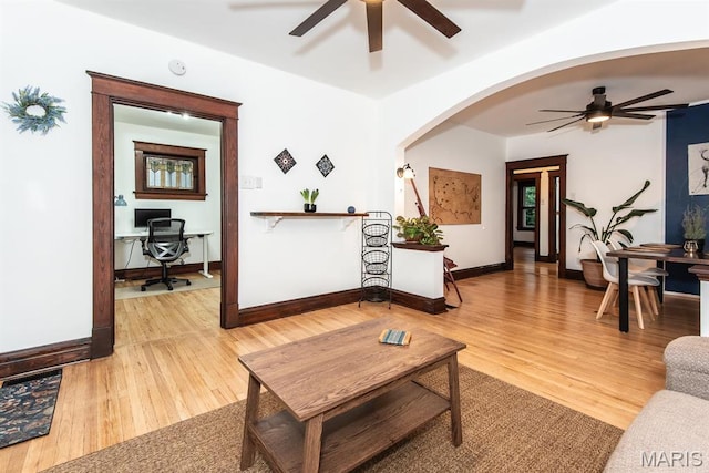 living room with a ceiling fan, a desk, and light wood-style floors
