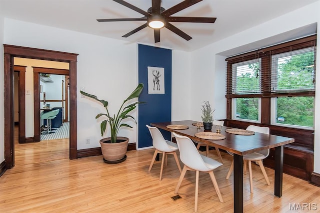 dining room with light wood-style flooring, a ceiling fan, and baseboards