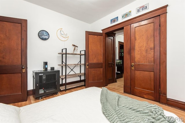 bedroom with light wood finished floors and baseboards