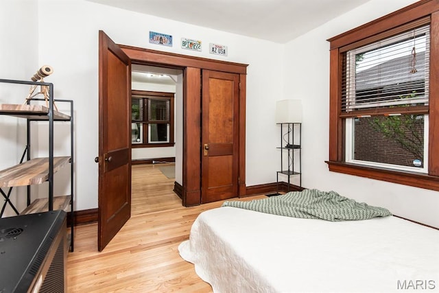 bedroom with light wood-style flooring and baseboards