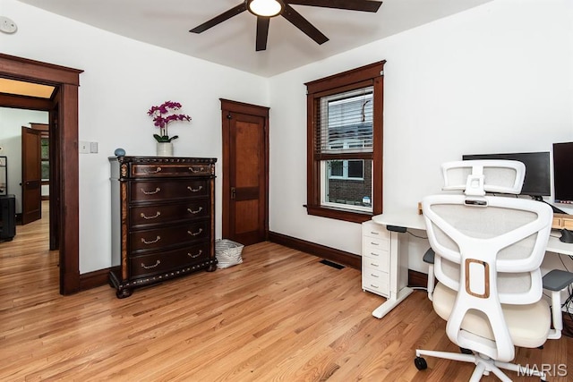 home office with a ceiling fan, light wood finished floors, and baseboards