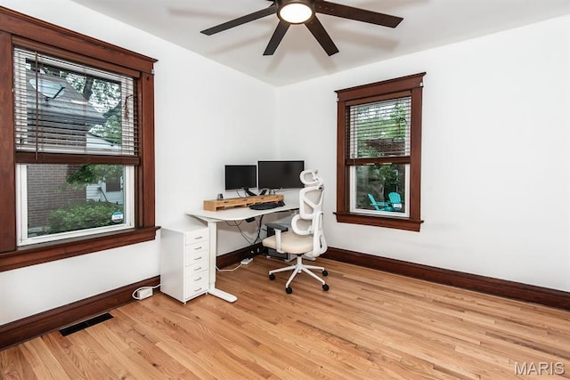 office space featuring baseboards, light wood-type flooring, and ceiling fan