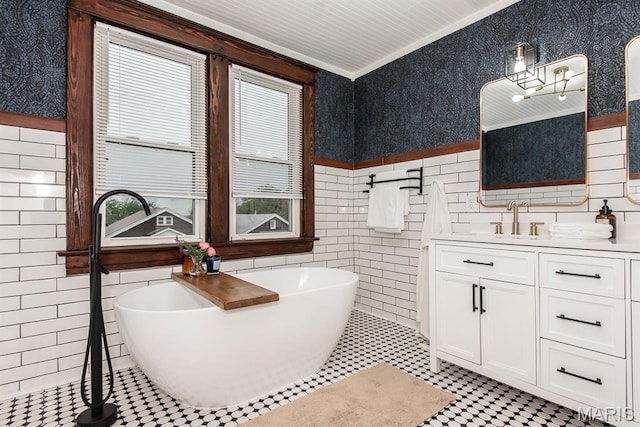 bathroom with tile walls, wainscoting, a freestanding tub, vanity, and ornamental molding