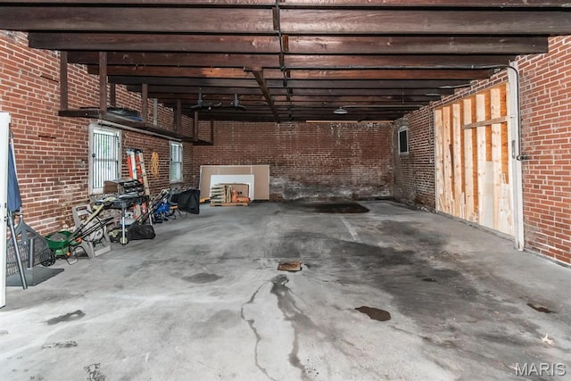 basement featuring brick wall and a garage