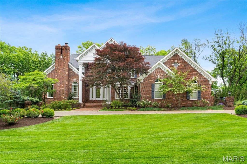7 Indian Creek Ln, Frontenac, MO 63131 - colonial-style house featuring a front lawn and brick siding
