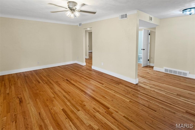 spare room featuring ceiling fan, light wood finished floors, and baseboards