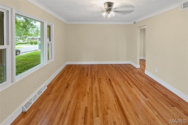 unfurnished room with light wood finished floors, a ceiling fan, and baseboards