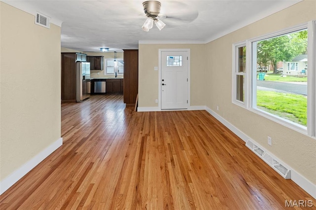 foyer with plenty of natural light, light wood finished floors, baseboards, and ceiling fan