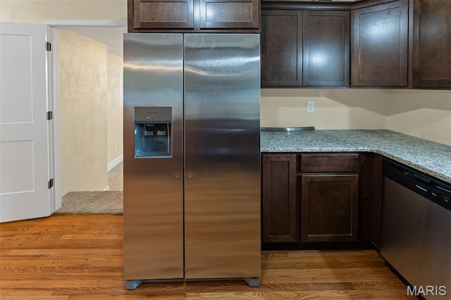 kitchen featuring stainless steel appliances, dark brown cabinetry, light wood-style flooring, and light stone countertops