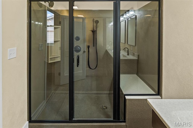 bathroom featuring vanity, a shower stall, and a textured wall