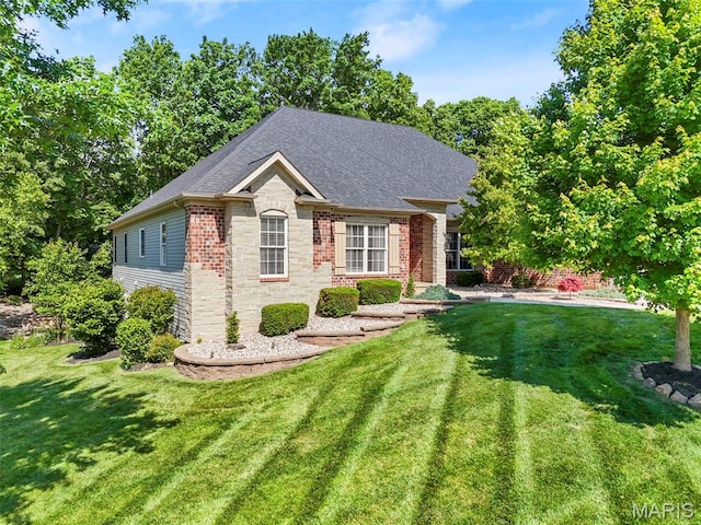1019 Hawks Landing Dr, Lake St Louis, MO 63367 - view of front of home featuring stone siding, a front lawn, and a shingled roof