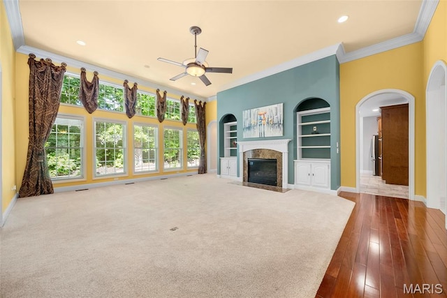 1019 Hawks Landing Dr, Lake St Louis, MO 63367 - unfurnished living room featuring crown molding, a ceiling fan, baseboards, built in features, and healthy amount of natural light
