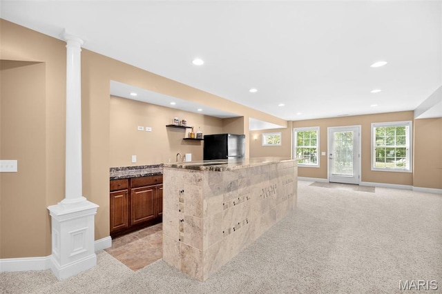 1019 Hawks Landing Dr, Lake St Louis, MO 63367 - kitchen with ornate columns, freestanding refrigerator, light carpet, light stone countertops, and recessed lighting