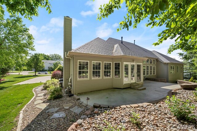 1019 Hawks Landing Dr, Lake St Louis, MO 63367 - rear view of house featuring a patio area, a chimney, a lawn, roof with shingles, and entry steps