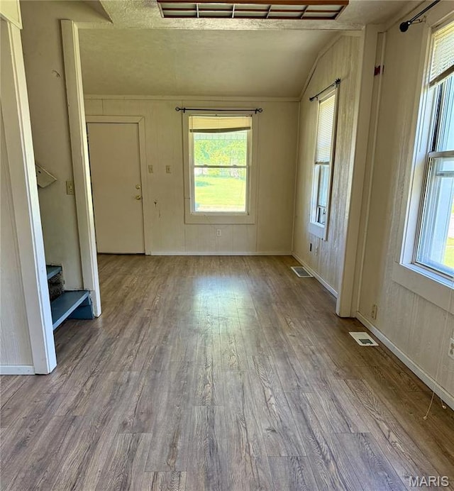 empty room with vaulted ceiling, wood finished floors, and baseboards