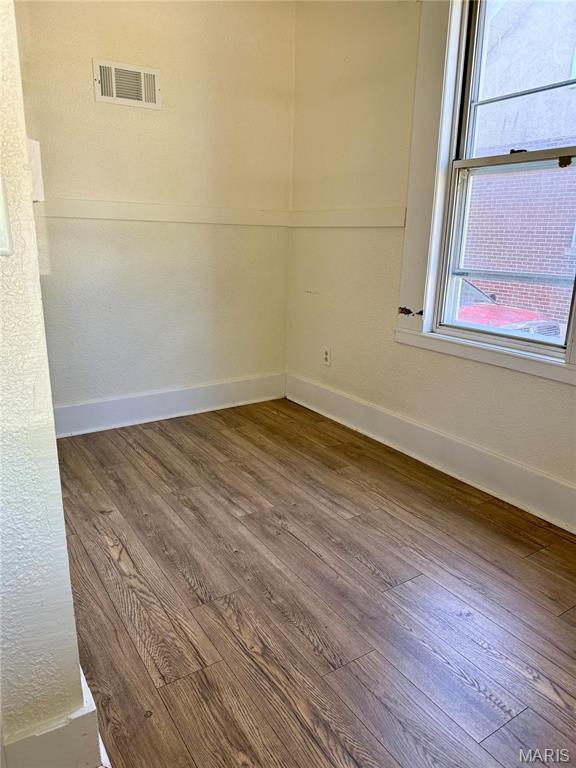 unfurnished room with wood finished floors and baseboards