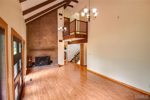968 Super Slab Rd, Greenfield, IL 62044 - unfurnished living room with a chandelier, high vaulted ceiling, stairs, beamed ceiling, and wood finished floors