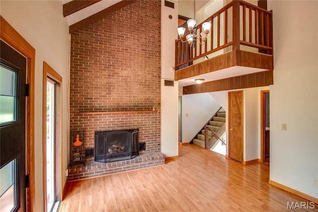 968 Super Slab Rd, Greenfield, IL 62044 - unfurnished living room featuring high vaulted ceiling, wood finished floors, stairs, a brick fireplace, and baseboards