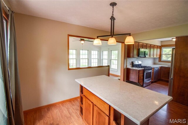 968 Super Slab Rd, Greenfield, IL 62044 - kitchen featuring stainless steel appliances, light countertops, light wood-type flooring, and brown cabinetry