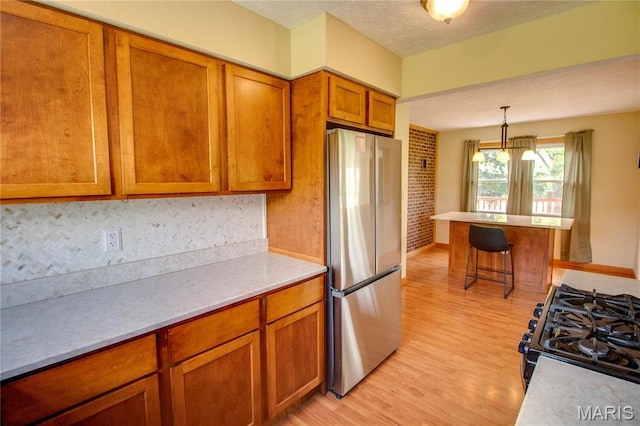 968 Super Slab Rd, Greenfield, IL 62044 - kitchen with freestanding refrigerator, light wood-type flooring, brown cabinets, a breakfast bar, and light countertops