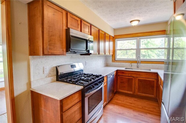 968 Super Slab Rd, Greenfield, IL 62044 - kitchen featuring stainless steel appliances, a sink, light countertops, light wood-style flooring, and backsplash