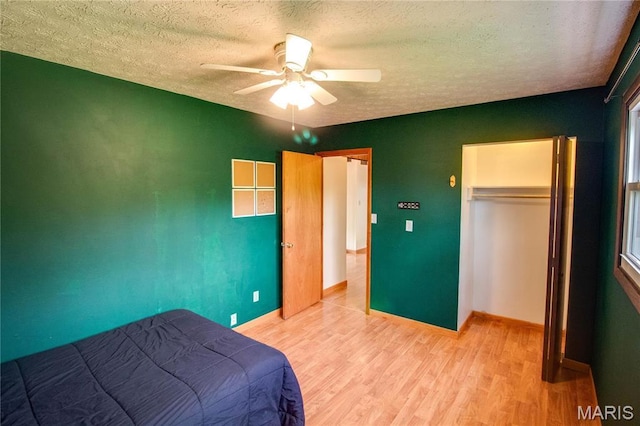 968 Super Slab Rd, Greenfield, IL 62044 - bedroom with a textured ceiling, light wood-style floors, a closet, baseboards, and a ceiling fan