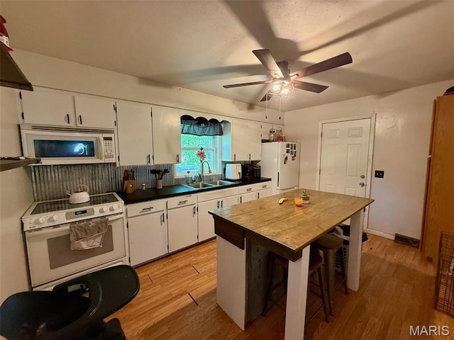 kitchen with white appliances, a sink, light wood-style floors, a ceiling fan, and white cabinets