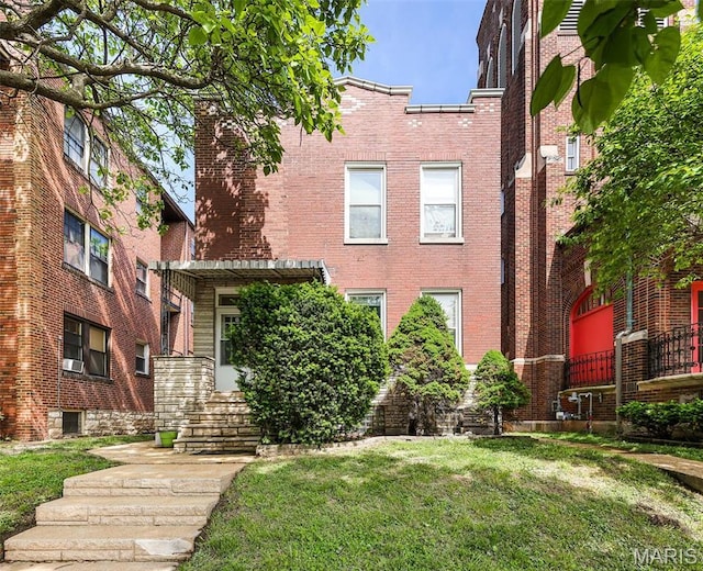 view of front facade featuring brick siding and a front yard