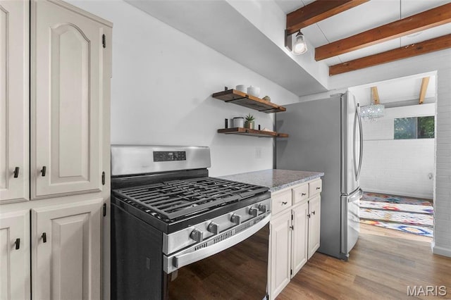 1353 Karen Dr, Cape Girardeau, MO 63701 - kitchen featuring stainless steel appliances, light wood-type flooring, light stone countertops, beamed ceiling, and white cabinets