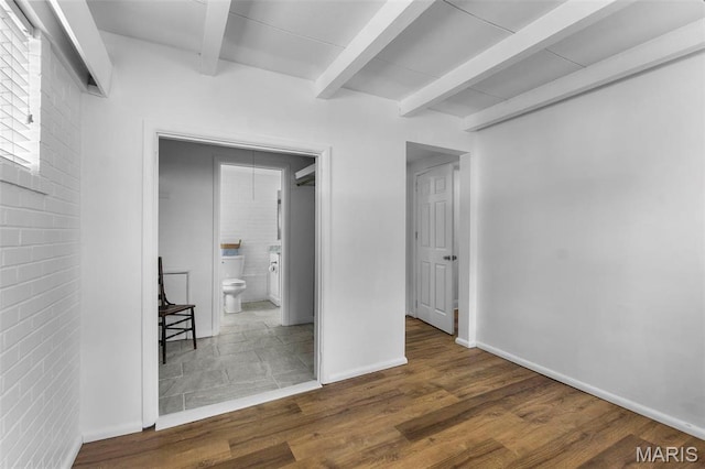 1353 Karen Dr, Cape Girardeau, MO 63701 - unfurnished bedroom with beamed ceiling, wood finished floors, baseboards, ensuite bath, and brick wall