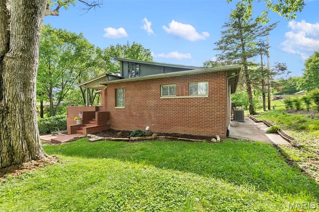1353 Karen Dr, Cape Girardeau, MO 63701 - back of house with central AC unit, a patio, a lawn, and brick siding